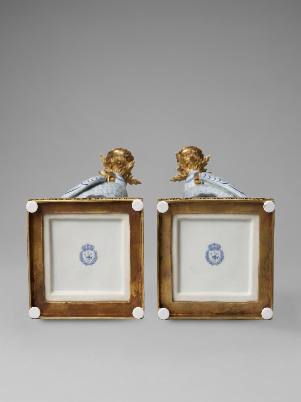 Paire de grands bougeoirs aux perroquets en porcelaine craquelée bleu ciel et bronze doré, dans un élégant goût néoclassique inspiré du style Louis XVI