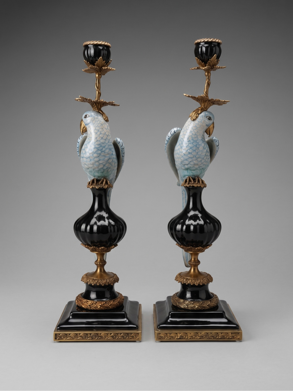 Paire de grands bougeoirs aux perroquets en porcelaine craquelée bleu ciel et bronze doré, dans un élégant goût néoclassique inspiré du style Louis XVI