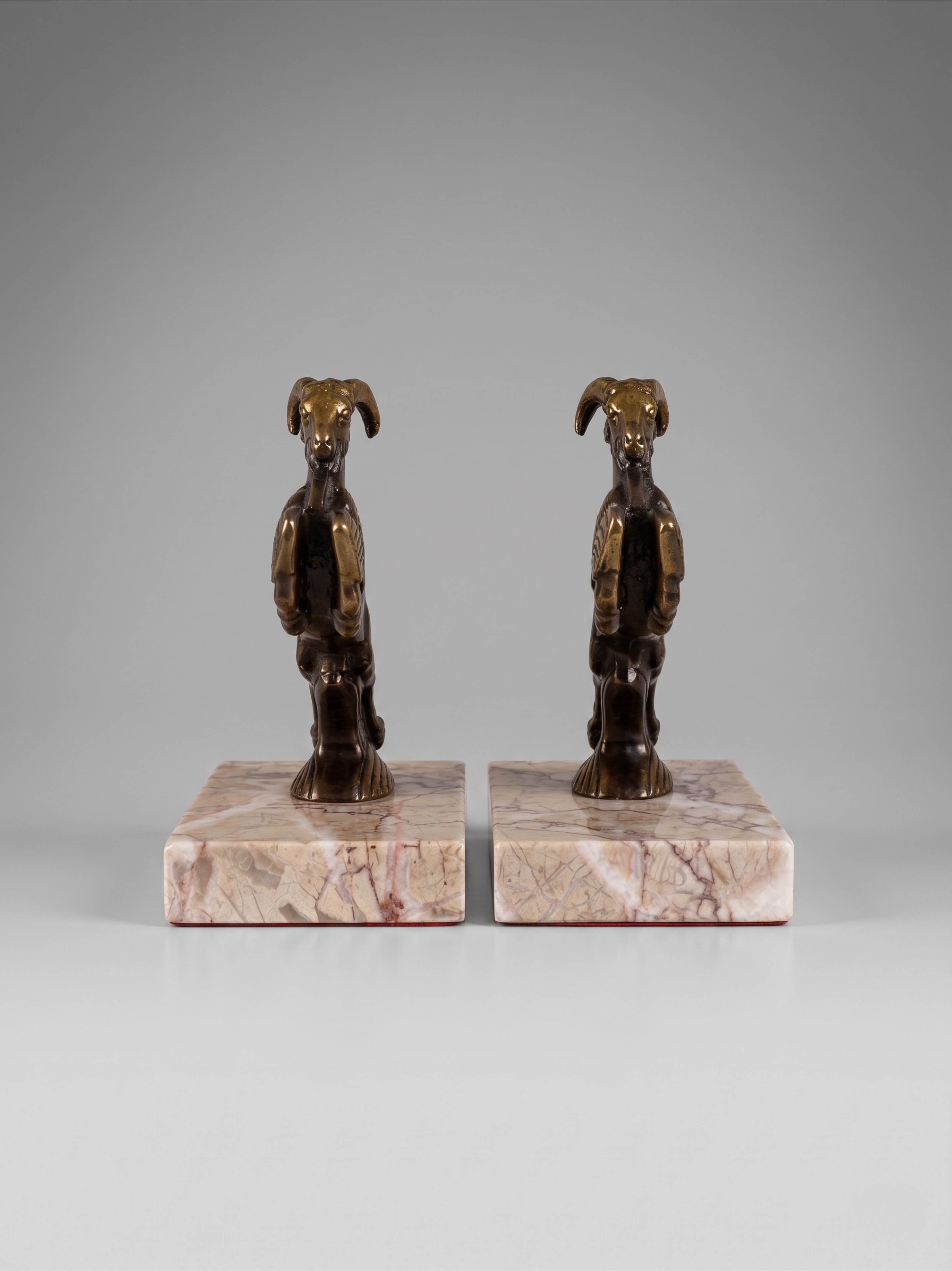 Pair of Art Deco ibex bookends in patinated spelter and veined marble, 1930s