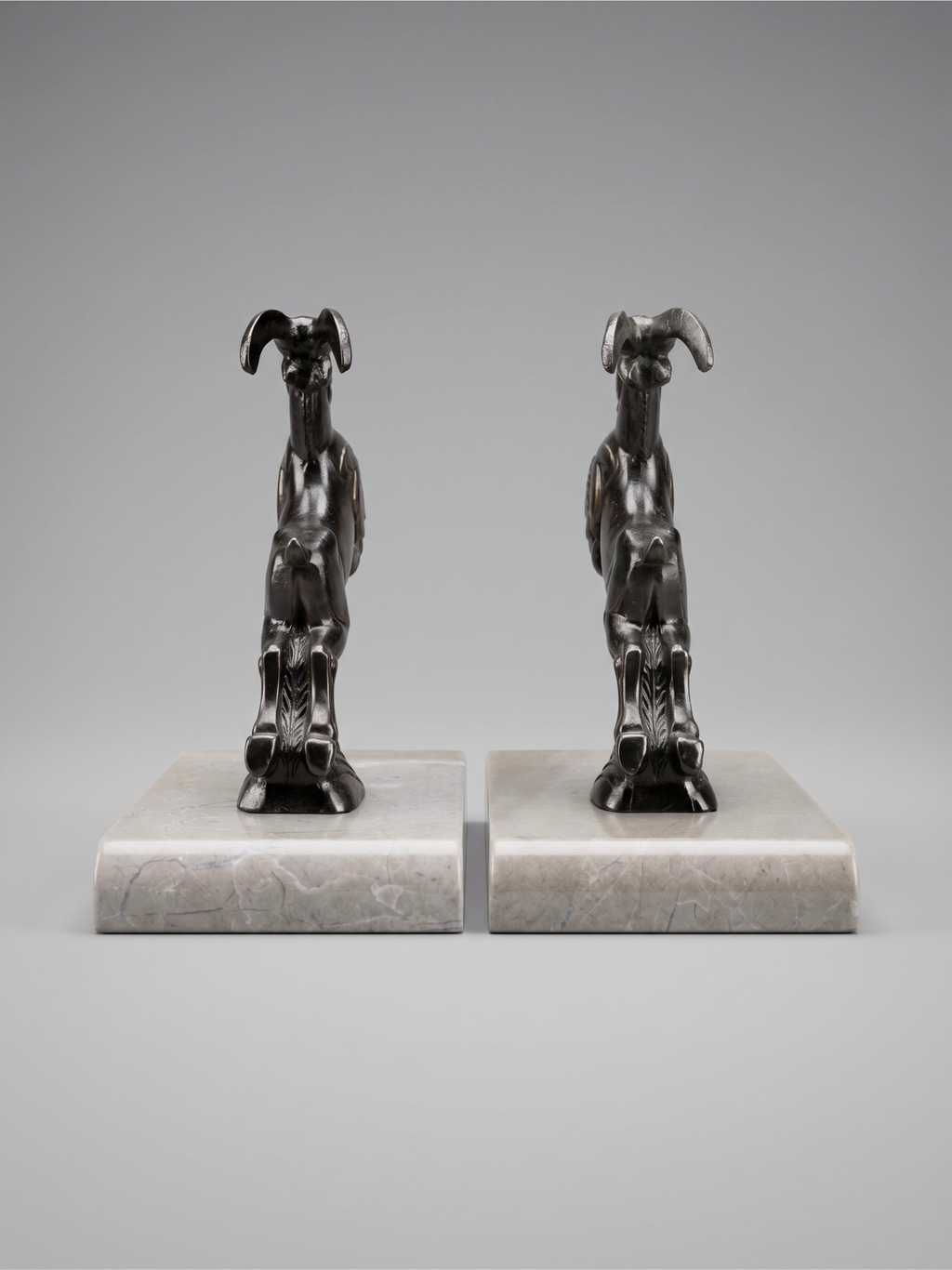 Serre-livres Art Déco bouquetins en régule patiné sur socle marbre taupe – paire années 1930