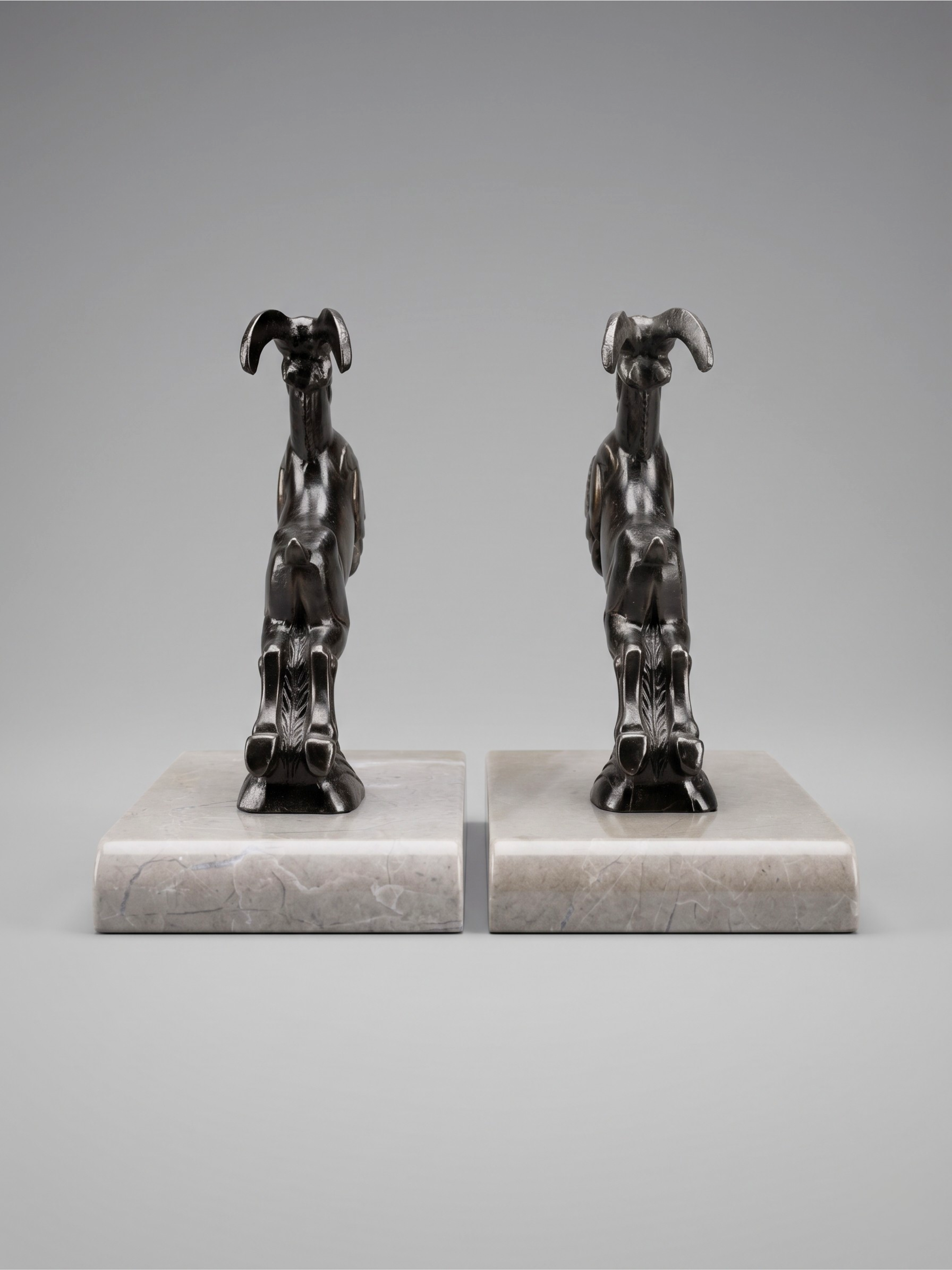 Art Deco ibex bookends in patinated spelter on taupe marble base – pair from the 1930s