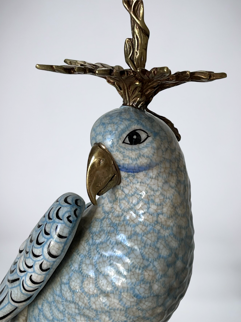 Paire de grands bougeoirs aux perroquets en porcelaine craquelée bleu ciel et bronze doré, dans un élégant goût néoclassique inspiré du style Louis XVI
