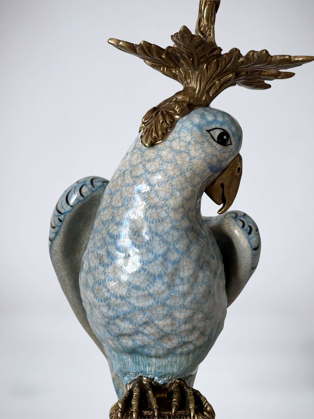 Paire de grands bougeoirs aux perroquets en porcelaine craquelée bleu ciel et bronze doré, dans un élégant goût néoclassique inspiré du style Louis XVI