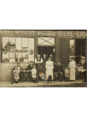 CPA photo – Café-débit de boissons animé Parisien, douze personnes et chien, vers 1910